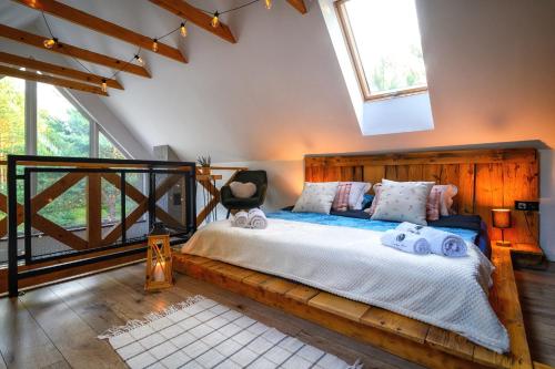 a bedroom with a wooden bed with towels on it at Dziupla House in Czarna