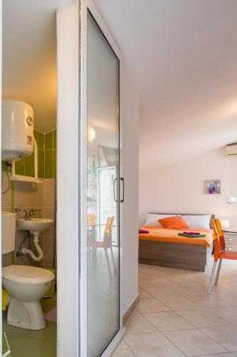 a bathroom with a glass door leading to a bedroom at Apartments Vila Masha in Petrovac na Moru