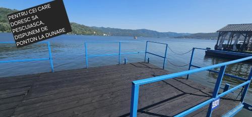 a dock with a sign next to the water at Sîrbu Orsova in Orşova