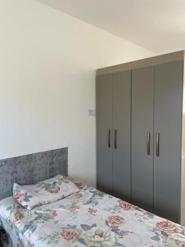a bedroom with a bed with a floral bedspread at Apartamento Confortável in Natal