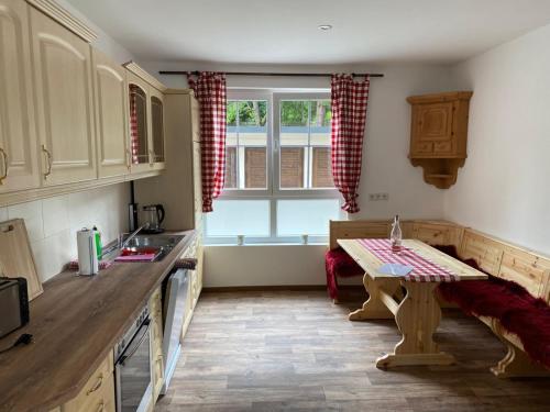 a kitchen with a table and a sink and a window at Ferienwohnungen Mai in Meiningen