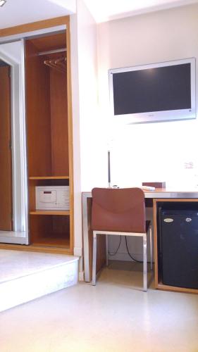a room with a desk with a television and a chair at Telmho Hotel Boutique in Buenos Aires