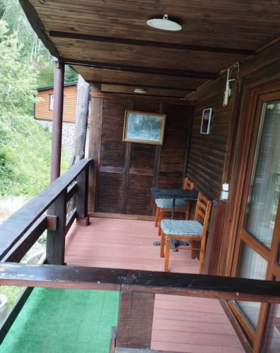 a porch of a cabin with a table and chairs at Zdybanka in Bukovel