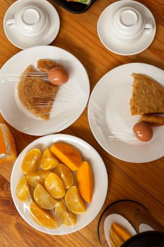 een tafel met borden met sinaasappelschijfjes bij Sumaku Beach House in Bwejuu