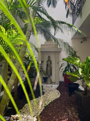 a garden with a statue in the middle of a building at Hotel Zendero Tulum in Tulum