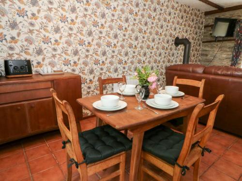 a wooden table with four chairs and a tableablish at The Stable in Llandysul