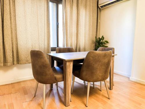 Un comedor con mesa y sillas de madera. en Modern 3BR Apartment Family Friendly Stay, en El Cairo