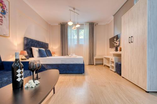 a bedroom with a bed and a table with a wine glass at Valery Apartments in Pefkohori