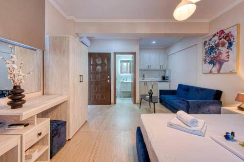 a living room with a blue couch and a table at Valery Apartments in Pefkohori