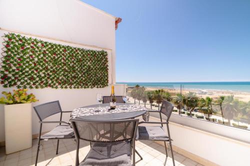 a table and chairs on a balcony with a view of the beach at MADAGÌ Beachfront Apartments in Pozzallo