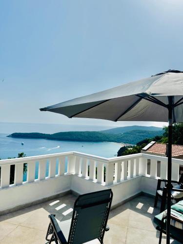 - un balcon avec des chaises et un parasol donnant sur l'océan dans l'établissement Budva Felix Suites, à Budva