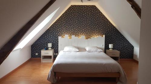 une chambre avec un grand lit dans un grenier dans l'établissement l'auberge du parachutiste, à Sainte-Mère-Église