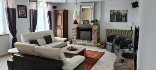 a living room with a couch and a fireplace at l'auberge du parachutiste in Sainte-Mère-Église
