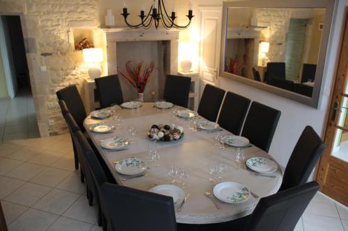 a dining room table with chairs and a large mirror at l'auberge du parachutiste in Sainte-Mère-Église