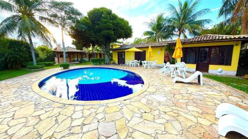 een zwembad in een tuin met een huis bij Casa em Condomínio Residencial Aroeira 500 m Da Praia - Geriba - Armação Dos Búzios in Búzios