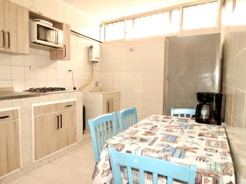 a kitchen with a table with blue chairs and a kitchen with a tableablish at Apartamento Edificio calima in San Andrés