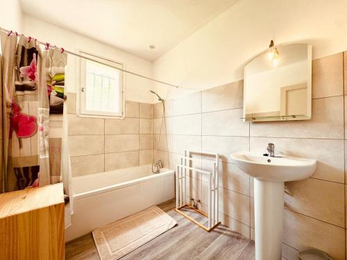 a bathroom with a sink and a bath tub at Maison entière tout confort pour 7 personnes in Bize-Minervois