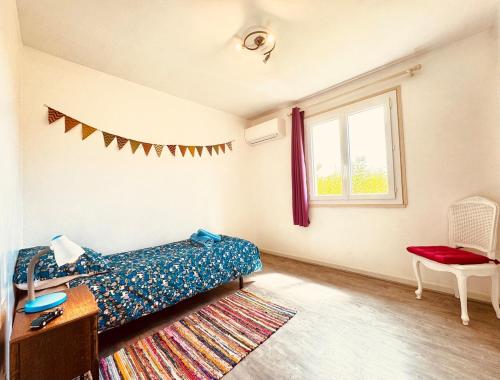 a bedroom with a bed and a window and a rug at Maison entière tout confort pour 7 personnes in Bize-Minervois