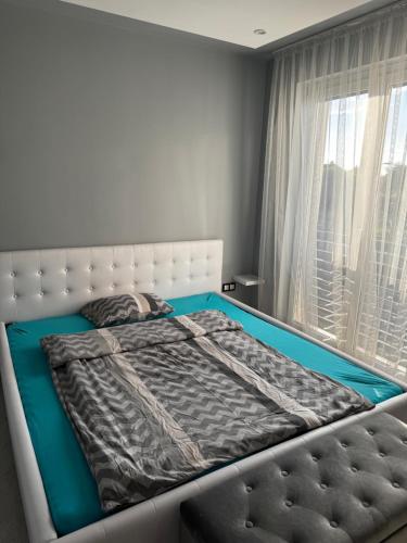 a bed in a room with a window and a bedskirtspectspectspectspects at Belle Casa Villa in Debrecen