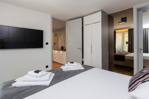 a bedroom with a large bed with a flat screen tv at Apartments AMALFI Old Town FREE Parking in Sarajevo