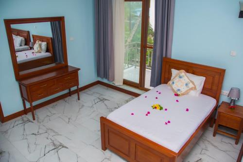 a bedroom with a bed and a mirror at Zamu Beach Retreat in Pwani Mchangani