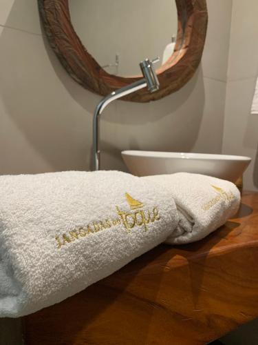 a bathroom with a white towel on a table at Jangadas do Toque Milagres Flats no Térreo in São Miguel dos Milagres