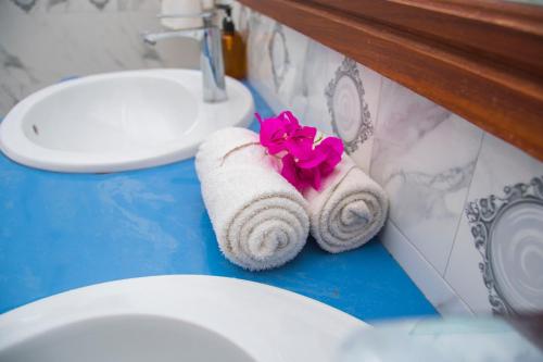 a bathroom with a towel with a flower in it at Zamu Beach Retreat in Pwani Mchangani