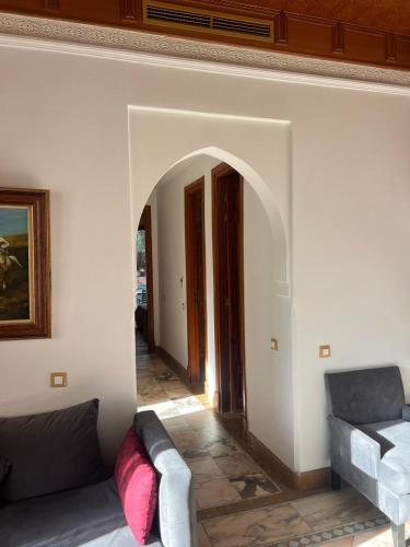 a living room with a couch and an archway at appartement chic avec piscine in Marrakech