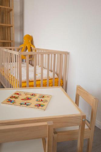 a crib with a table and a table and a chair with a crib at 4-room apartment in the heart of Chemnitz in Chemnitz