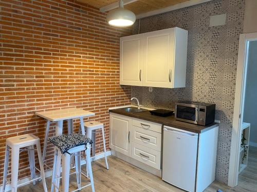 a kitchen with white appliances and a brick wall at House in nature with a spa and large garden 