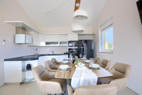 a kitchen and dining room with a table and chairs at Penthouse Sophia in Medulin