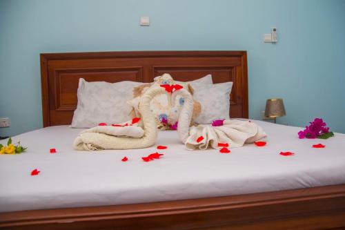 a bed with two towels and flowers on it at Zamu Beach Retreat in Pwani Mchangani