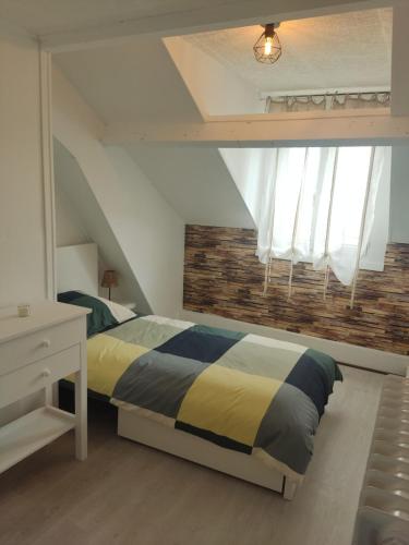 a bedroom with a bed and a brick wall at Lycot in Dompierre-Becquincourt