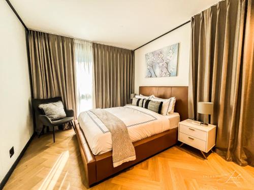 a bedroom with a bed with a chair and a window at KML Nine Palms luxury 101 in Cape Town