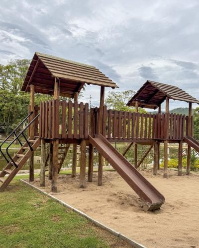 a wooden playground with a slide in a park at Hotel Fazenda RosaBlue in Presidente Getúlio