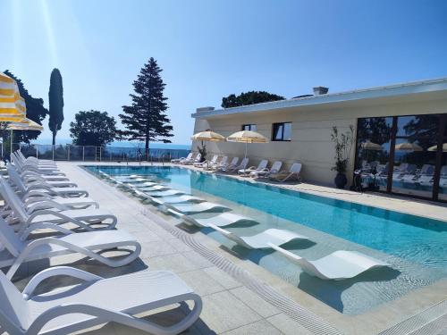 ヴァルナ・シティにあるEuroproperties SkyLine Apartmentsの建物の隣にある長椅子のあるプール