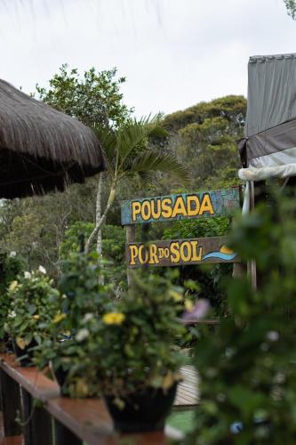 a street sign for a resort with plants at Pousada Do Sol Ilha do Mel in Paranaguá