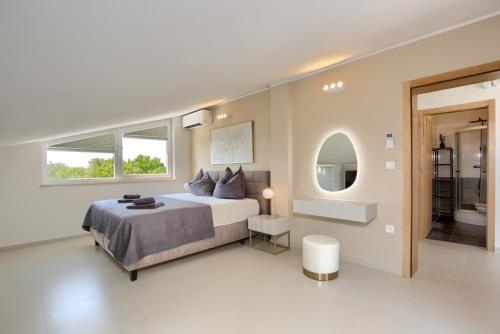 a white bedroom with a bed and a window at Penthouse Sophia in Medulin