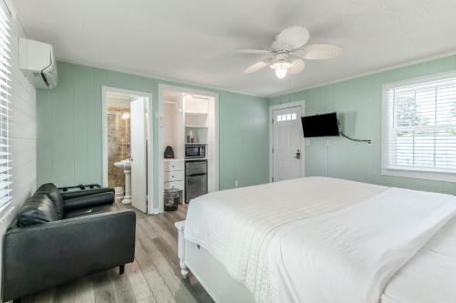 a bedroom with a large white bed and a couch at Island Guesthouse and Motel OBX in Manteo