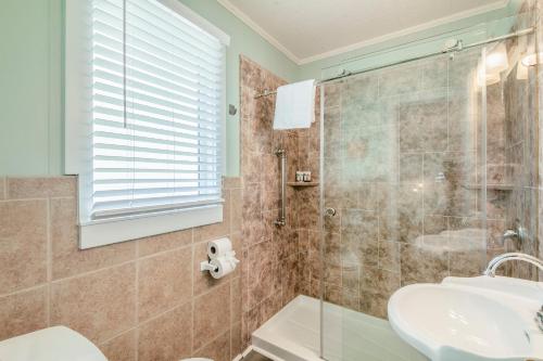 a bathroom with a shower and a sink at Island Guesthouse and Motel OBX in Manteo
