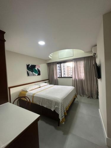 a hotel room with a bed and a window at Residencial Pasárgada, apto 602 in Vila Velha