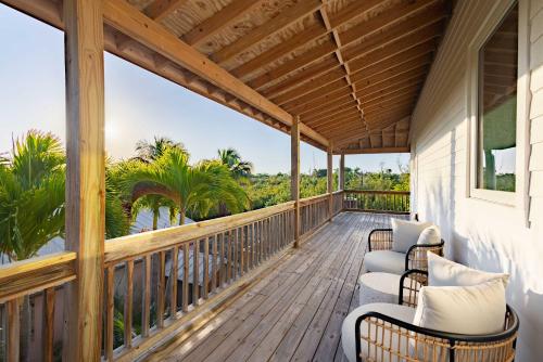 a porch with chairs and a view of the ocean at Starlight Serenity - Hideaway with Stunning Views in Pirates Cove