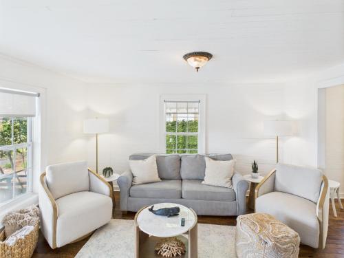 a living room with a couch and two chairs at Coastal Cottage in Port Saint Joe