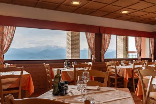 a restaurant with tables and chairs and a large window at Hotel & Restaurant AL TRIVIO in Altana