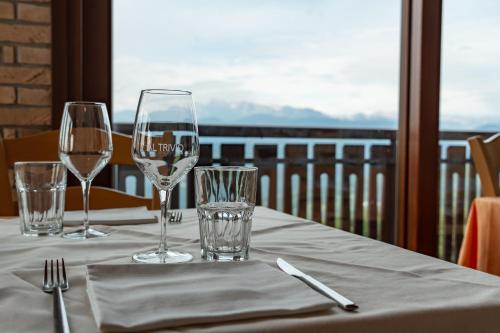 a table with wine glasses and a view of a balcony at Hotel & Restaurant AL TRIVIO in Altana