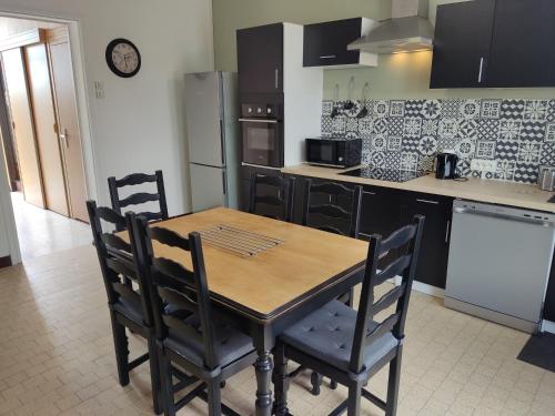 une cuisine avec une table en bois et deux chaises dans l'établissement Lycot, à Dompierre-Becquincourt