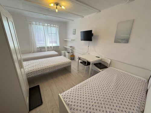 a small room with two beds and a desk at Dom Gościnny Danuta in Rewal