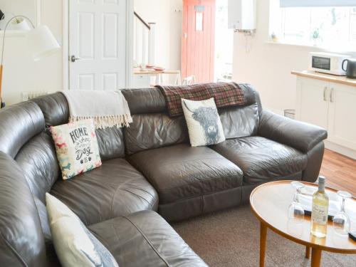 a leather couch in a living room with a table at Swan's Nest - Uk43545 in Belford