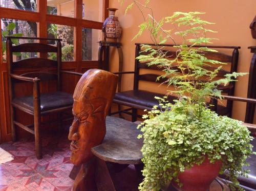 a room with two chairs and a statue and a plant at Hospedaje Turistico Recoleta in Cusco