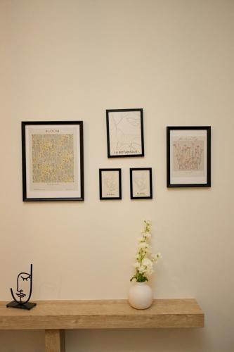 a wall with four framed pictures on a white wall at Blisséa in Piraeus